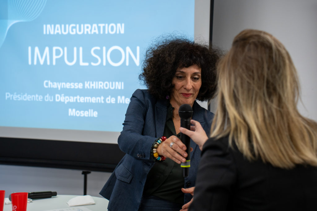 Photo de Laure Vaquier, directrice d'Impulsion, donnant son micro à Chaynesse Khirouni, Présidente du Département de Meurthe-et-Moselle, lors de l'inauguration d'Impulsion.
