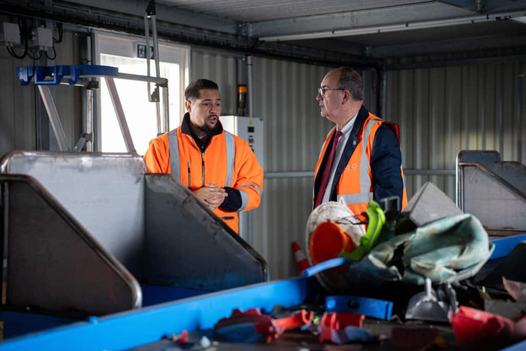 Philippe Deschamps et Quentin Ehlinger se tenant devant la chaîne de tri de plastique du groupe VALO'. 