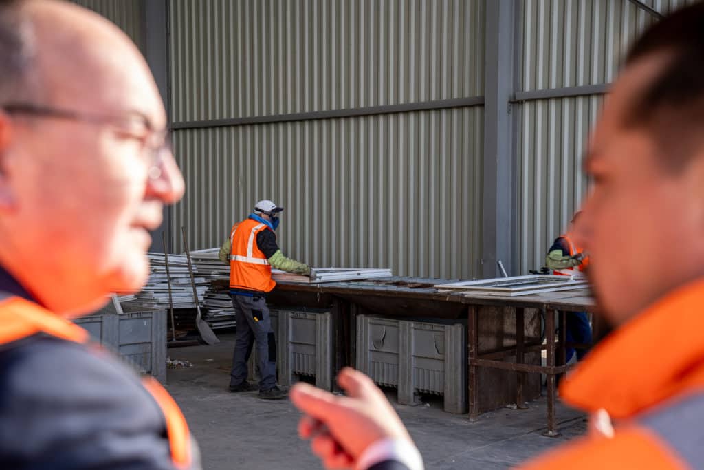 Photo de Quentin Ehlinger et de Philippe Deschamps devant une démonstration de démantèlement d'une huisserie en fin de vie. 