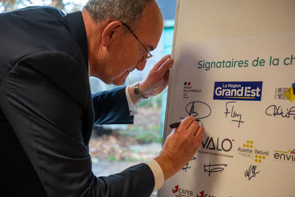 Photo de Philippe Deschamps, Sous-Préfet de Thionville, qui signe le panneau de la charte pour une Économie Circulaire et Inclusive sur le territoire de l'OIN Alzette-Belval, en délégation du monsieur le Préfet Touvet. 