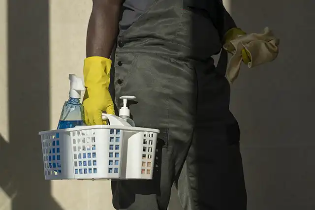 nettoyage-parties-communes-panier-produits-menage Un employé VALO'Propreté tient son matériel de nettoyage